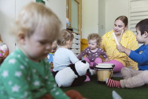 Barnen musiserar tillsammans med en vuxen.
