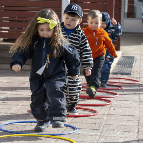 Children are outdoors on an obstacle course.