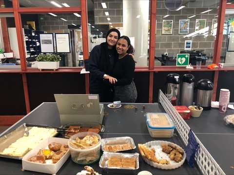 Two ib-students standing behind a table full of baked goodies