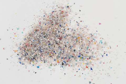 Colourful shredded plastic on a light-coloured surface. 