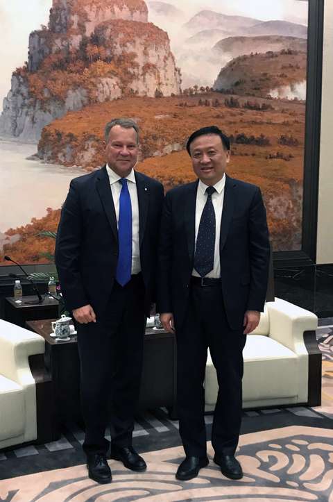 Två män står framför en stor tavla.