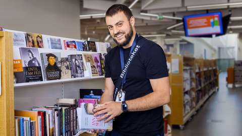 Jonne Taipale with a book in his hands in the Iso Omena Library.