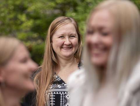 Jenni and Emilia looking at each other and Tiina Pajula smiling in the background.
