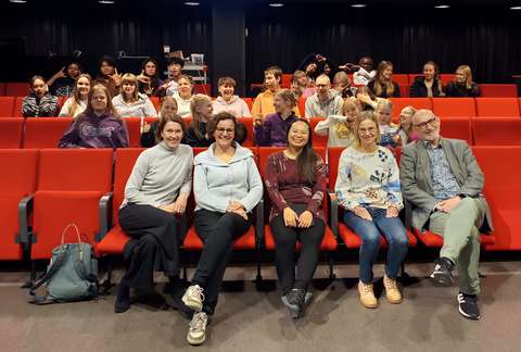 opettajia ja opiskelijoita istuu salissa