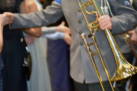 Puolustusvoimien varusmiessoittokunnan muusikko tervehtii oppilasta.