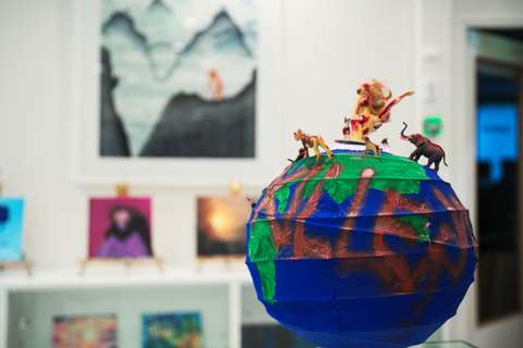 taideteos jossa maapallo ja sen päällä eläimiä