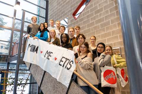 Opiskelijat seisovat Etiksen käytävän rappusilla ja he pitelevät lakanaa, jossa lukee Minä, Me, Etis.