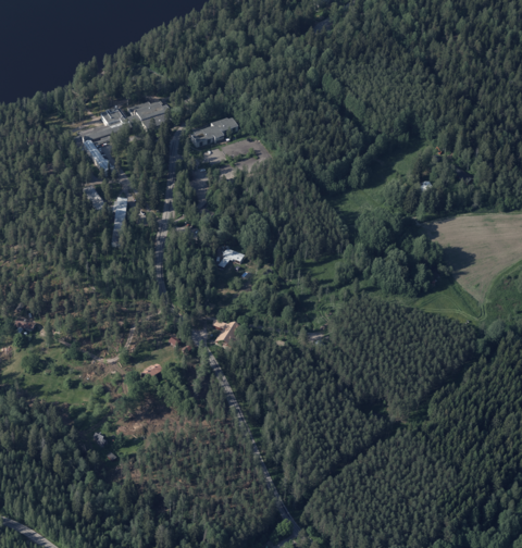Ilmasta otetussa kuvassa näkyy paljon metsää, jonka seassa on muutamia rakennuksia ja niittymäisiä alueita.