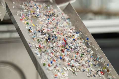 Colourful shredded plastic in a metal tray.
