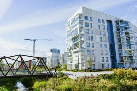 A bridge, part of the park and apartment buildings.