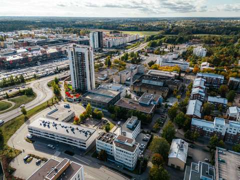  Flygfoto som visar byggnader, vägar, tågspår och träd.