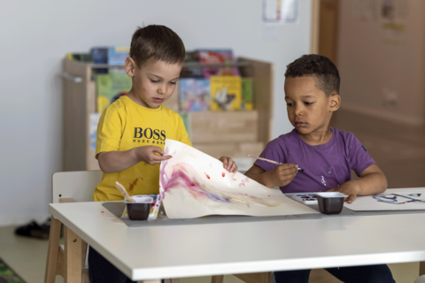 Kaksi lasta tekee maalausta.