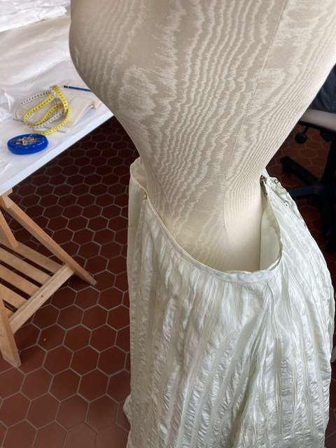 Vaatetuen päällä valkoisen hameen sovitus.