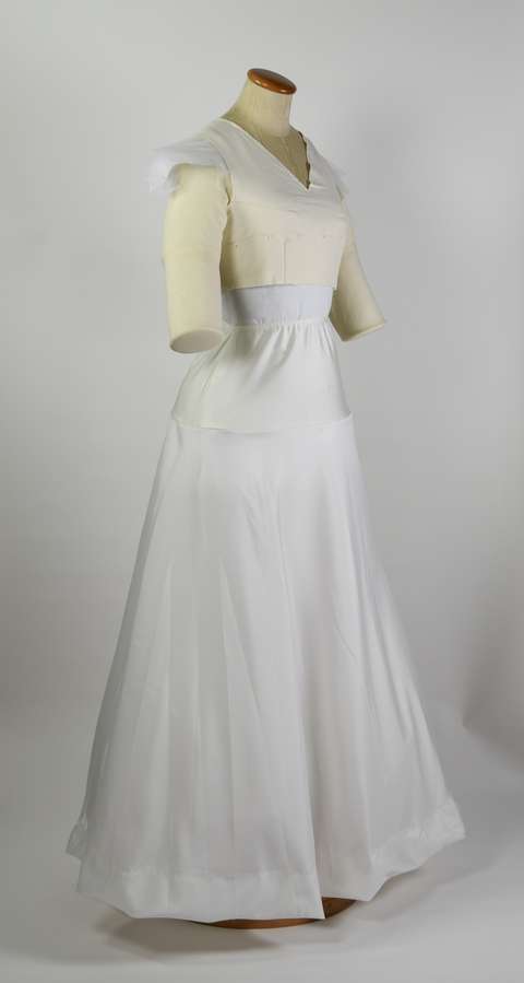 Valkoinen 100-vuotta vanha mekko vaatetuella.