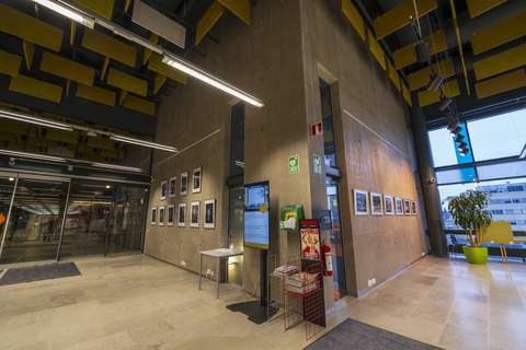 Betoninen seinä, jolle on ripustettu tauluja.