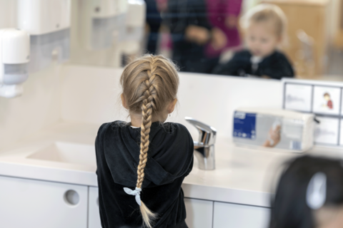  Barnet tvättar sina händer.