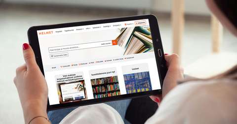 A person holds a tablet with the home page of the new Helmet online library on the screen.