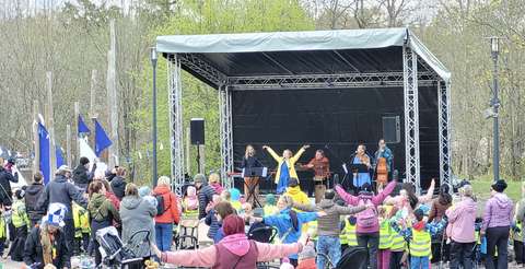 Ulkolavalla lastenmusiikkiyhtye sekä yleisöä.
