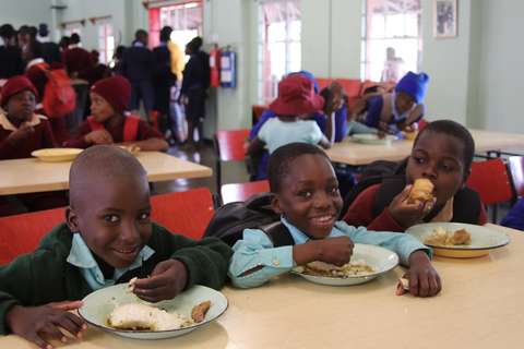 Lapset hymyilevät ja syövät zadzaa.