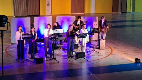 Opiskelijoiden bänsi esiintyy liikuntasalissa.