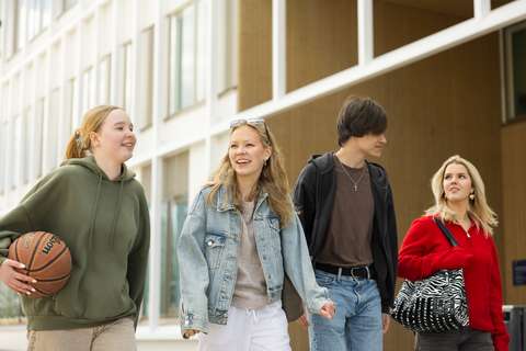 opiskelijat koulun edessä matkalla koripallokentälle