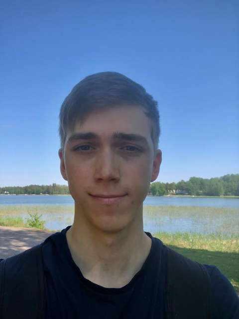 Kuvassa nuori henkilö musta paita päällä, takana vesialue