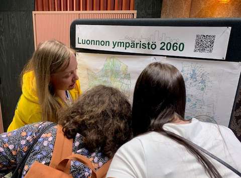 Kaupungin työntekijät keskustelevat asukkaiden kanssa tilaisuudessa.