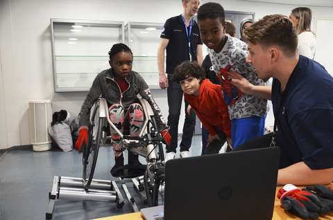 Lapsia ja nuoria kokeilemassa digitaalista ratakelaussimulaattoria.