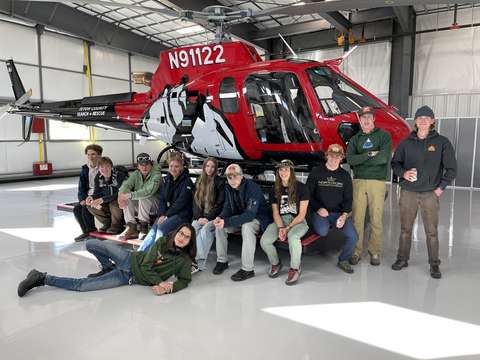 Nuoria punaisen helikopterin edessä.