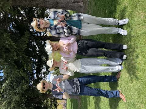 Neljä opiskelijaa cowboy-hatut päässä näyttä sormilla w-kirjainta.