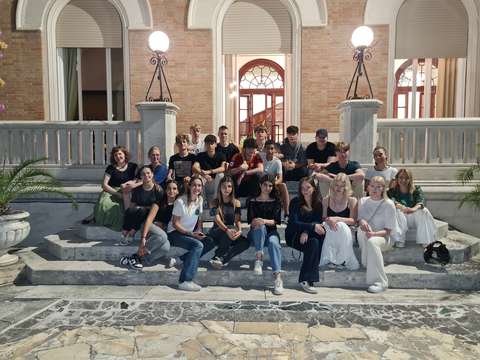 suomalaiset ja italialaiset ryhmäkuvassa koulun rappusilla puutarhassa