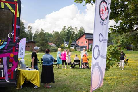Ihmisiä Senioripakun pysäkillä Hiirisuon asukaspuiston edustalla.