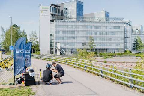 Kaksi aikuista huoltaa polkupyörää Keilaniemen edustalla