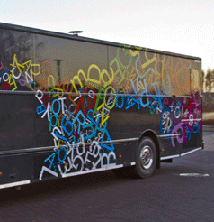 Kirjastoauto Välkky. Musta bussi ja kuvituksena kirjaimia.