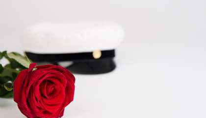 Punainen ruusu ja ylioppilaslakki.