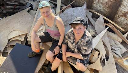 SISU-kollektiivin kaksi jäsentä istuvat kierrätysmateriaalien päällä. 