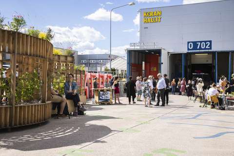 Ihmisiä kokoontuneena ulkona Keran Hallien edustalla aurinkoisena päivänä.