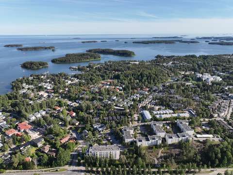 Ilmakuvassa meren rannalta näkyy rakennuksia mantereella. Rannikon edustalla näkyy pieniä saaria.