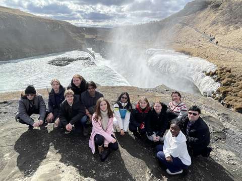 opiskelijoita kuuman lähteen ja vesiputouksen edessä