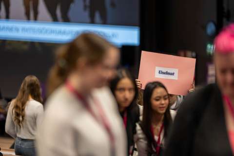 Kuulumme yhdessä -tapahtuman nuoria yhdessä menossa ryhmätyötiloihin työskentelemään kantaen kylttiä, jossa lukee "unelmat" 