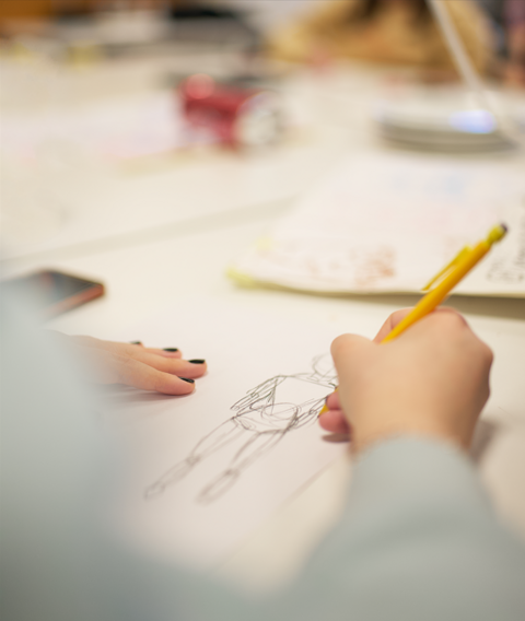 Opiskelija piirtämässä.