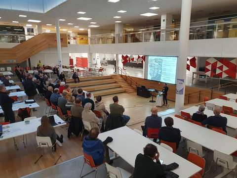 Ihmisiä katsomassa esitystä valkokankaalta.