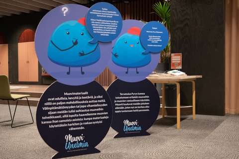 Large floor plates have a blue character made of plastic and some text.