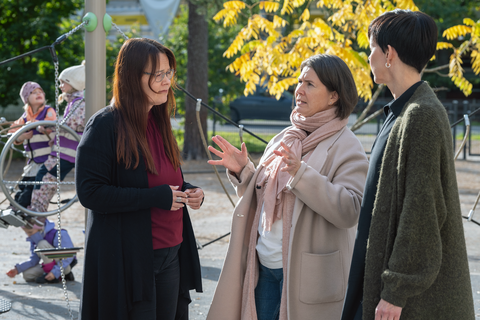 The daycare director, the district manager, and the assistant director are talking in the daycare yard.