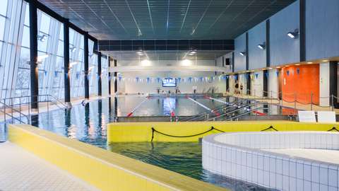 The picture shows the big swimming pool at the Keski-Espoo swimming hall.