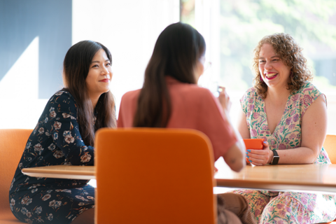 Kolme naishenkilöä pöydän äärellä.