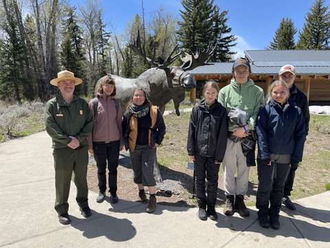Opiskelijat rangerin ja hirvipatsaan kanssa.