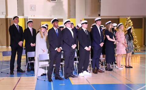 uudet ylioppilaat seisovat riveissä lakki päässä