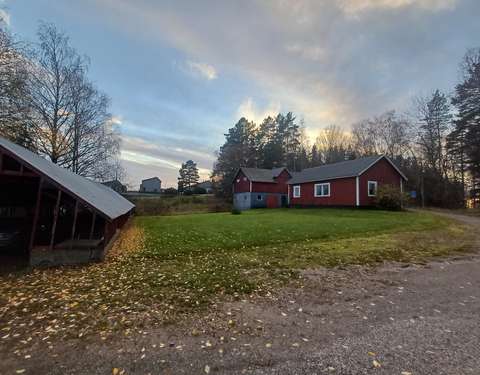 Utsikt från Sandåkersvägen mot gatan Brinkesmalmen. På bilden syns byggnader, en sluttning och trädbestånd.