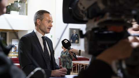 Kai Mykkänen intervjuas av media i Esbo stads fullmäktigegården.